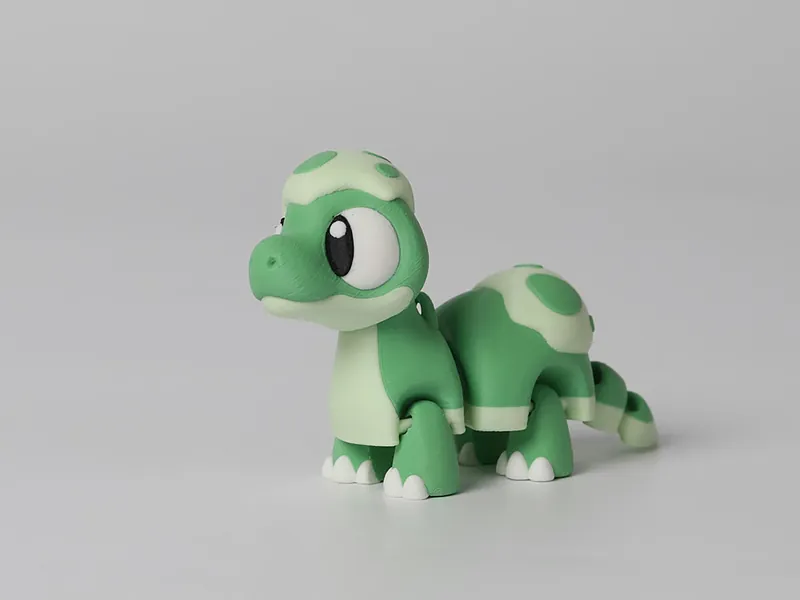 Dinossauro articulado impresso em 3D em dois tons de verde