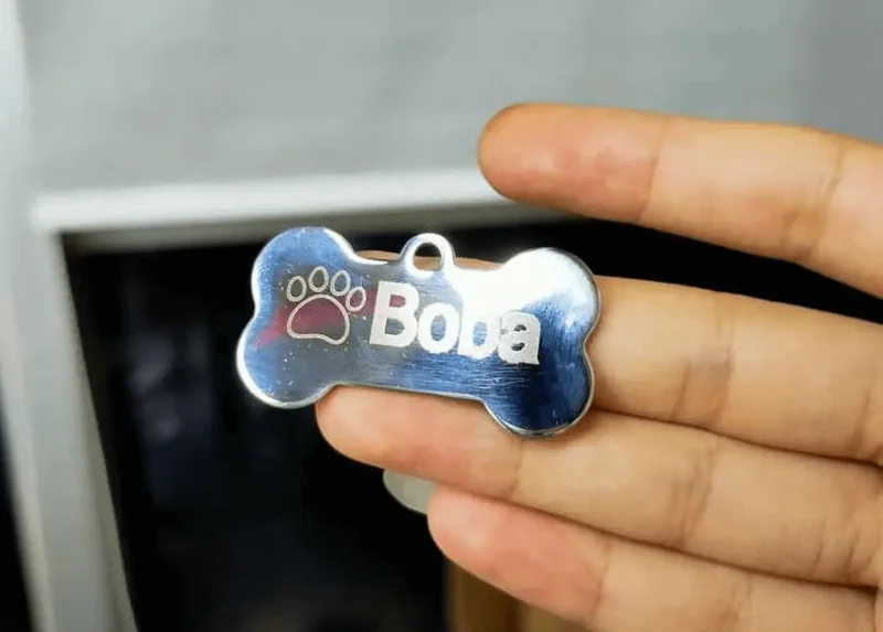 Plaquinha de identificação em metal, gravada a laser, segura na mão