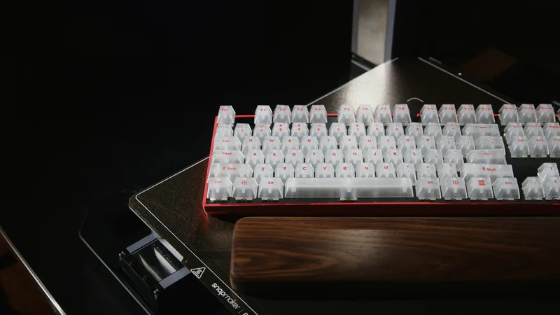 Teclado mecânico com teclas translúcidas impressas em 3D, sobre a mesa de uma impressora Snapmaker