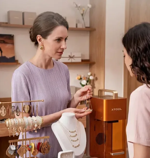 Vendedora atendendo um cliente com a xTool F2 no balcão