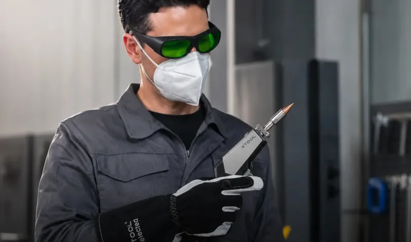 Operador com óculos de proteção e luvas segurando a tocha da MetalFab