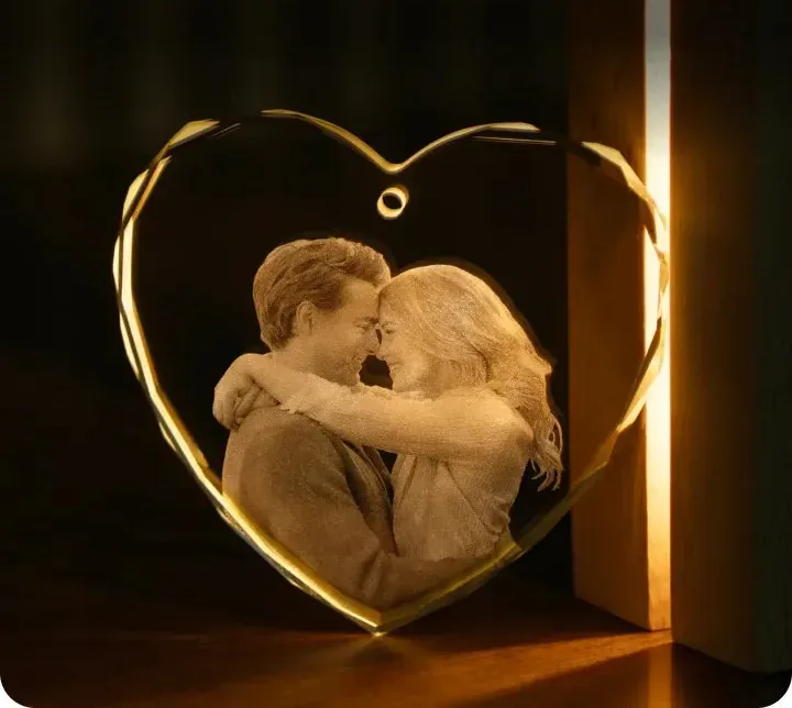 Cristal em forma de coração com a foto de um casal gravada por dentro, iluminado